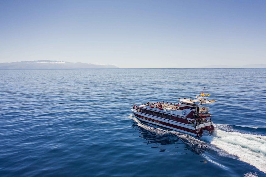 A large boat with passengers on a calm sea. 1