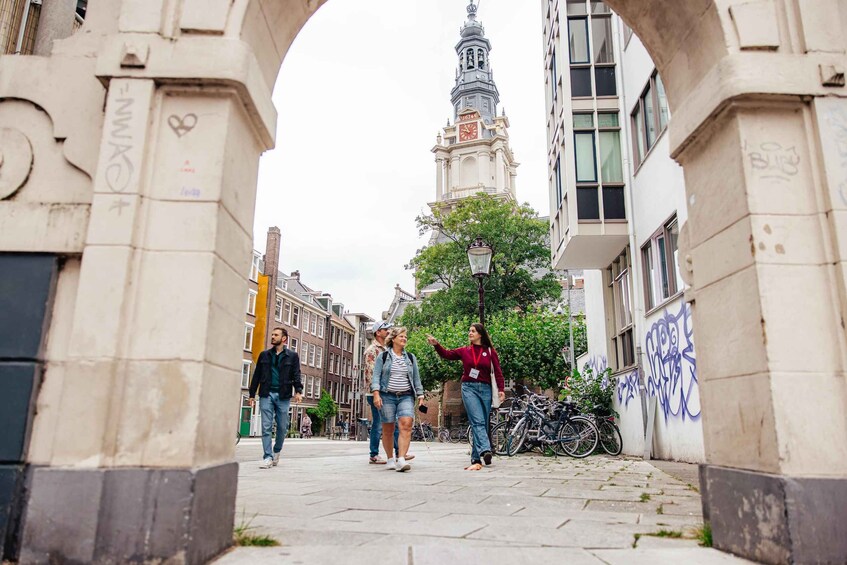 A pedestrian walkway with an archway, a clock tower, and bicycles parked along the side. 5