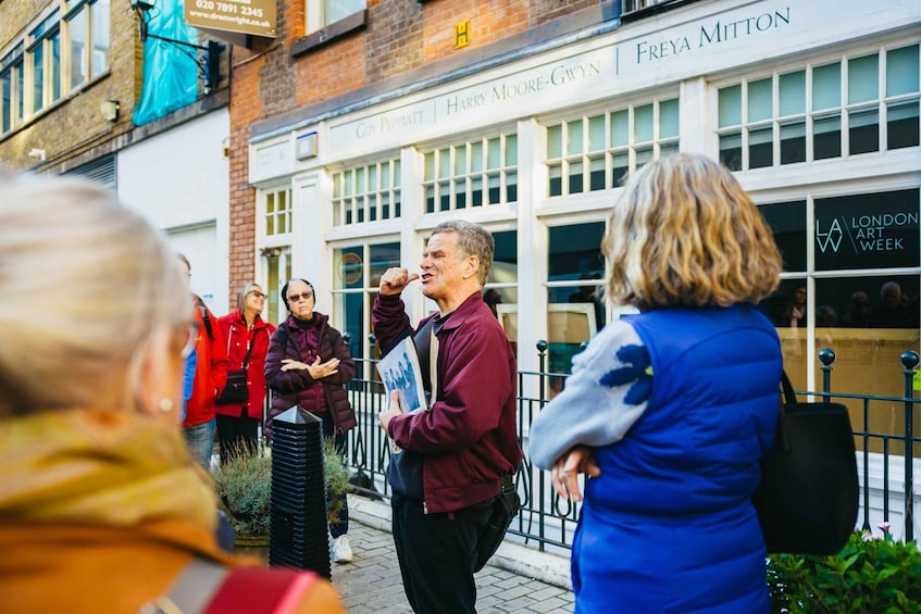People standing outside a building with signs for 'Harry Moore-Gwyn' and 'Freya Mitton'. 1