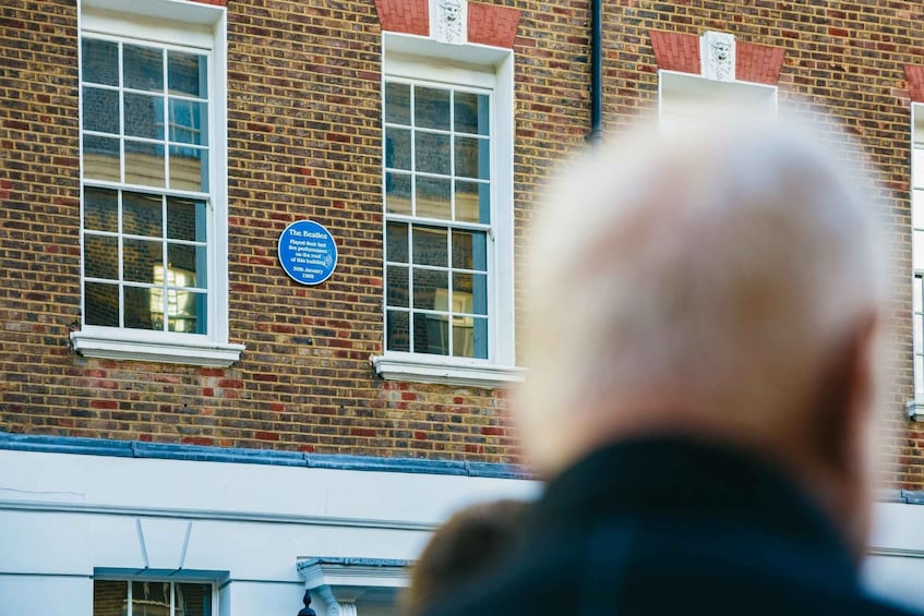 A brick building with two windows and a plaque. 5