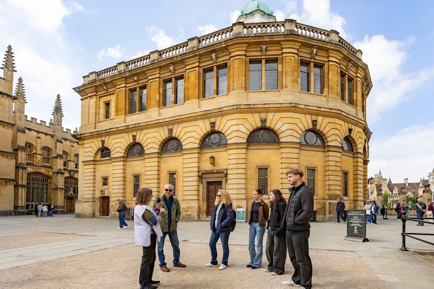 A historic building with a curved facade, arched windows, and a green dome. 1