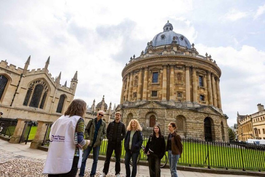 A group of people standing in front of a historic building with a dome and arches. 4