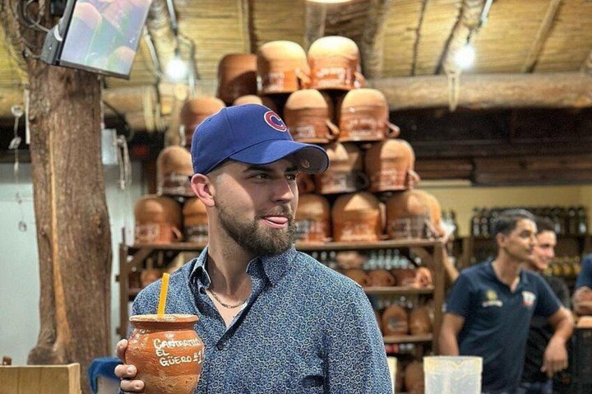 A person holding a clay pot in a store with shelves of similar items in the background. 3