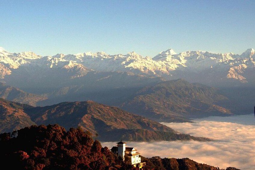 A mountainous landscape with snow-capped peaks, a monastery, and a valley below. 2