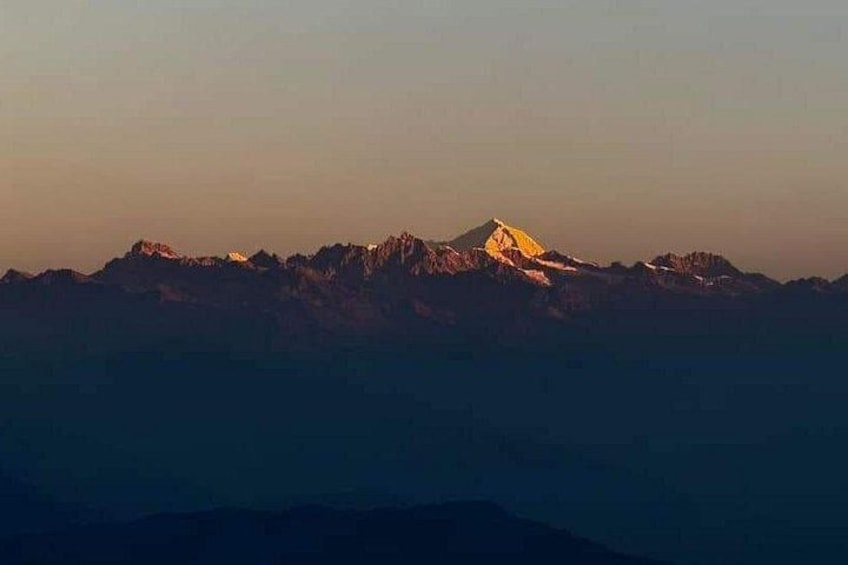 A mountain range with a prominent peak illuminated by sunlight. 2