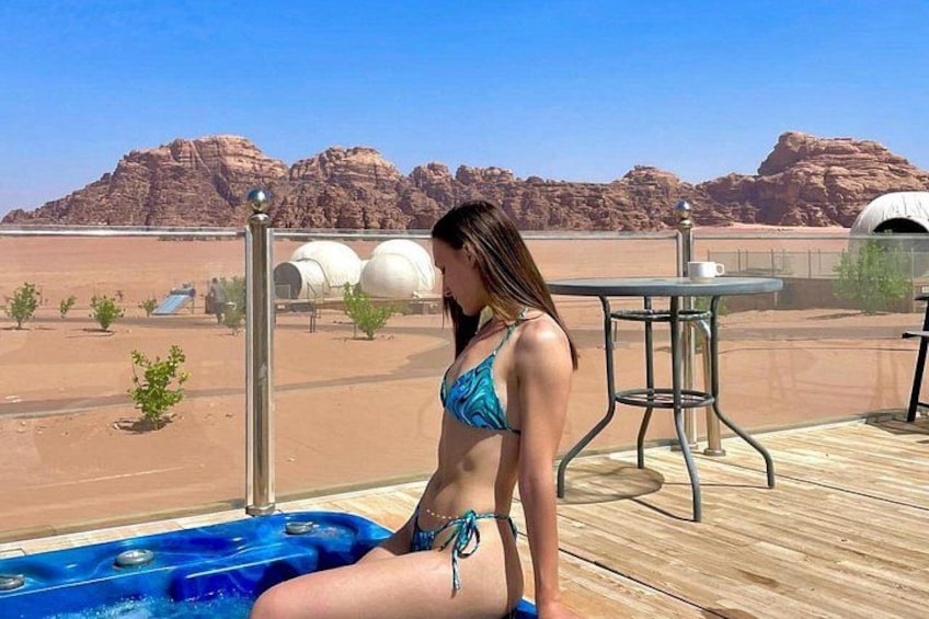 A woman in a bikini sitting by a pool with desert scenery in the background. 3