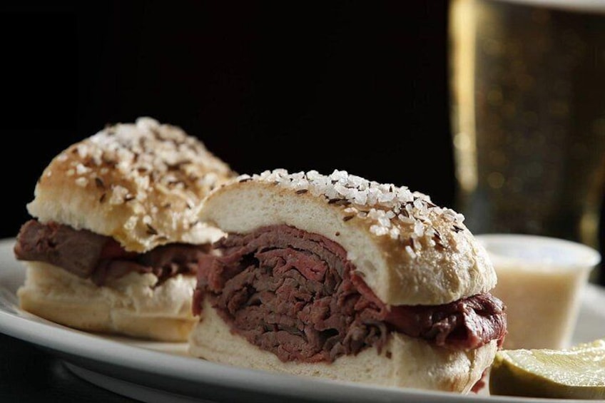 Ein Sandwich mit Brötchen, Fleischfüllung und Essiggurken als Beilage. 2