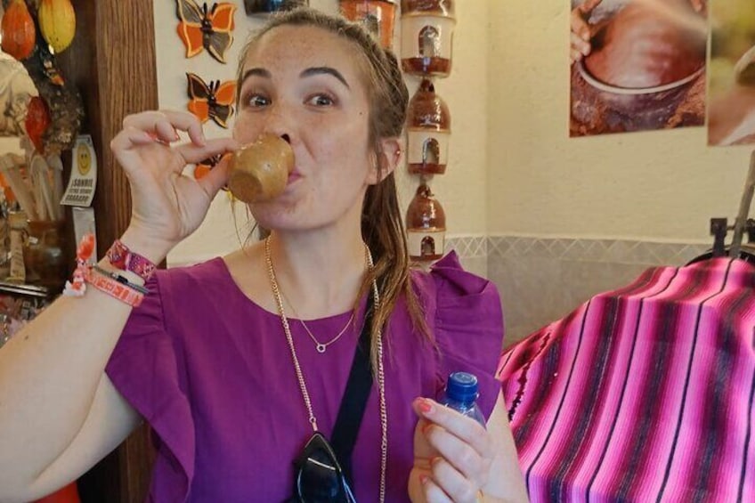 A person in a purple shirt holding a bottle and a donut. 2