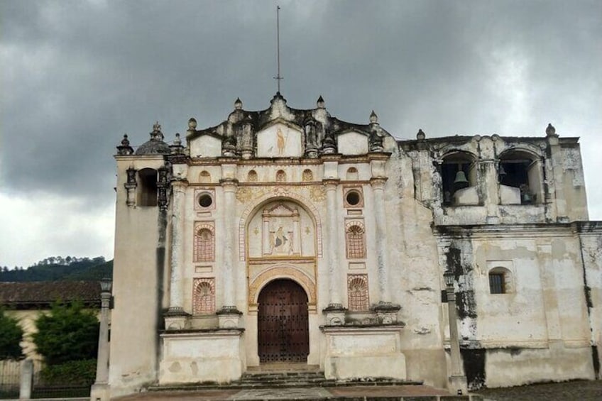 A historic building with a large wooden door, ornate arches, and a bell tower. 5