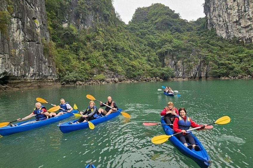 People kayaking on a calm river surrounded by rocky cliffs and lush greenery. 2