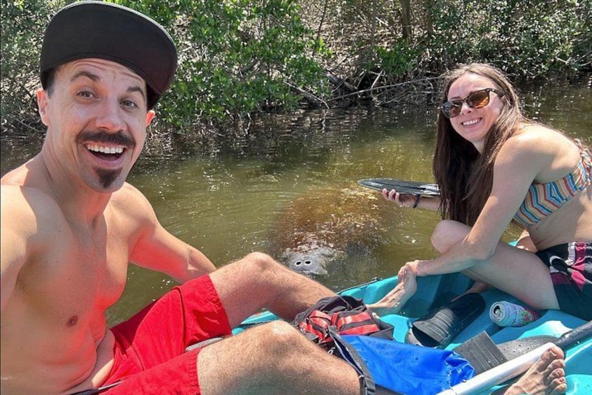 Two people in a boat on a calm body of water surrounded by greenery. 1