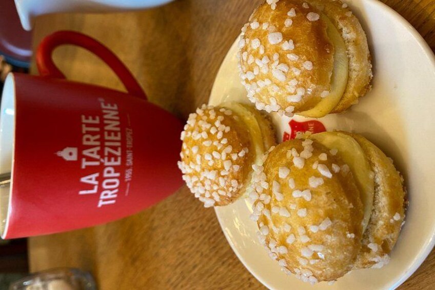 A plate with three pastries topped with white sugar, a red mug with text, and a wooden table. 3