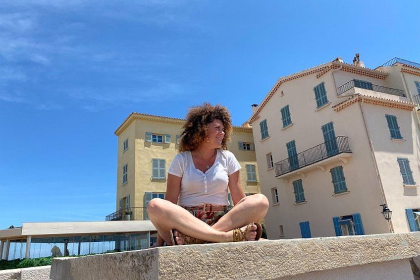 A person sitting on a concrete ledge with buildings in the background. 5