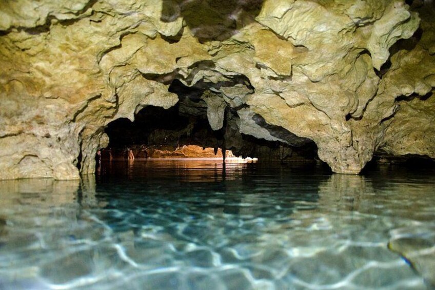 Une grotte avec de l’eau claire et une structure en bois à l’intérieur. 2