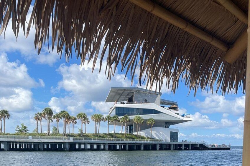 Una casa moderna con un diseño único, ubicada en un muelle a la orilla del agua, rodeada de palmeras. 3
