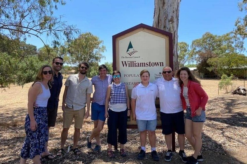 A group of people standing in front of a sign that reads 'Williamstown.' 1