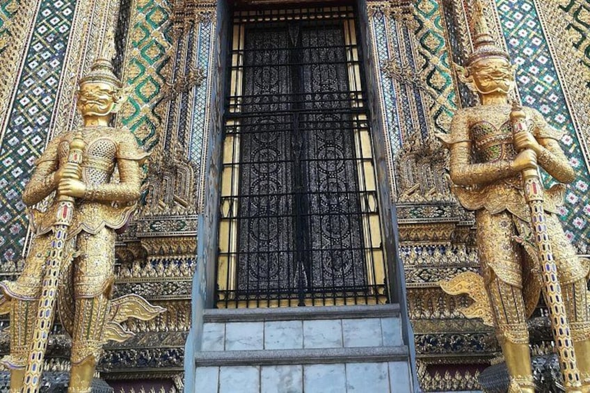 Une statue dorée, dotée d’un couvre-chef finement travaillé, une porte noire et des décorations murales élaborées. 3