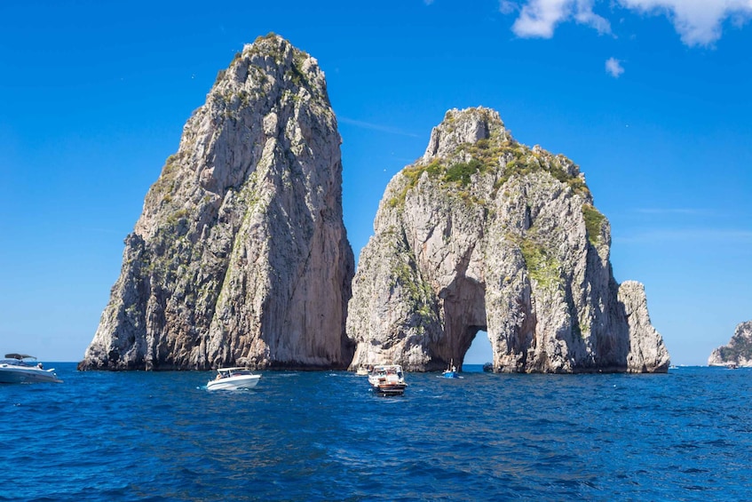 Un bateau naviguant entre deux grandes formations rocheuses dans la mer. 1