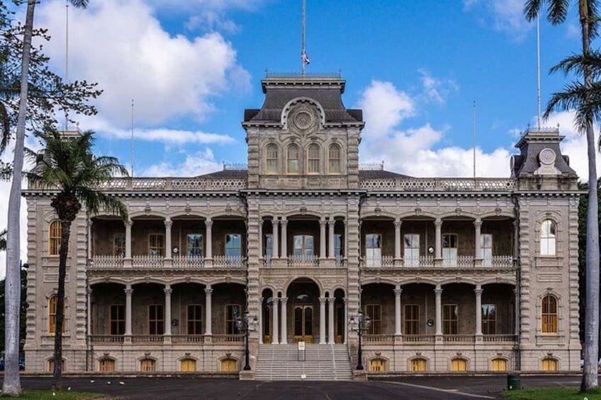 Un edificio grande e histórico con varios balcones y una entrada central. 2