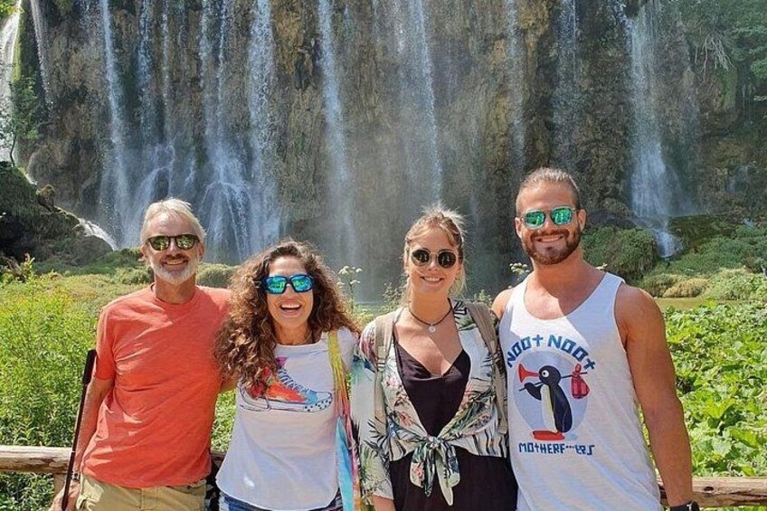 Un grupo de personas de pie frente a una cascada. 2
