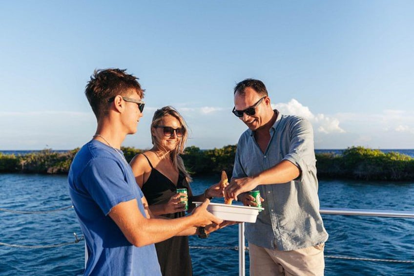 Trois personnes à bord d’un bateau, dont une qui distribue des boissons. 2
