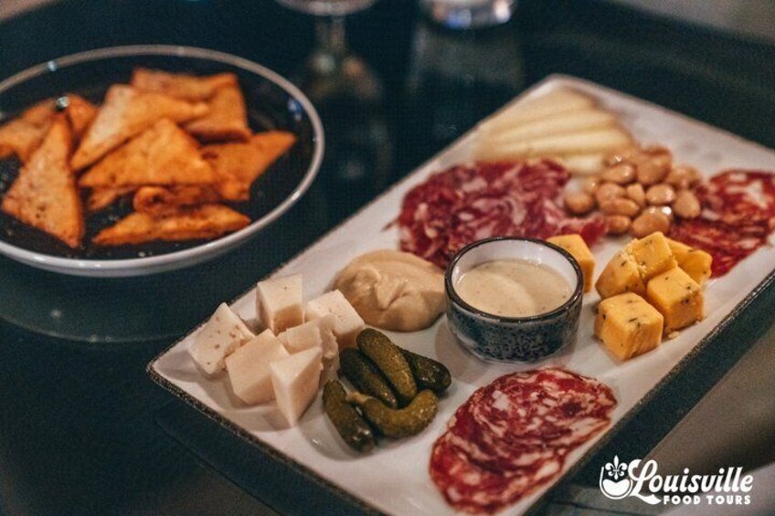 A charcuterie board with various cheeses, meats, and pickles. 2