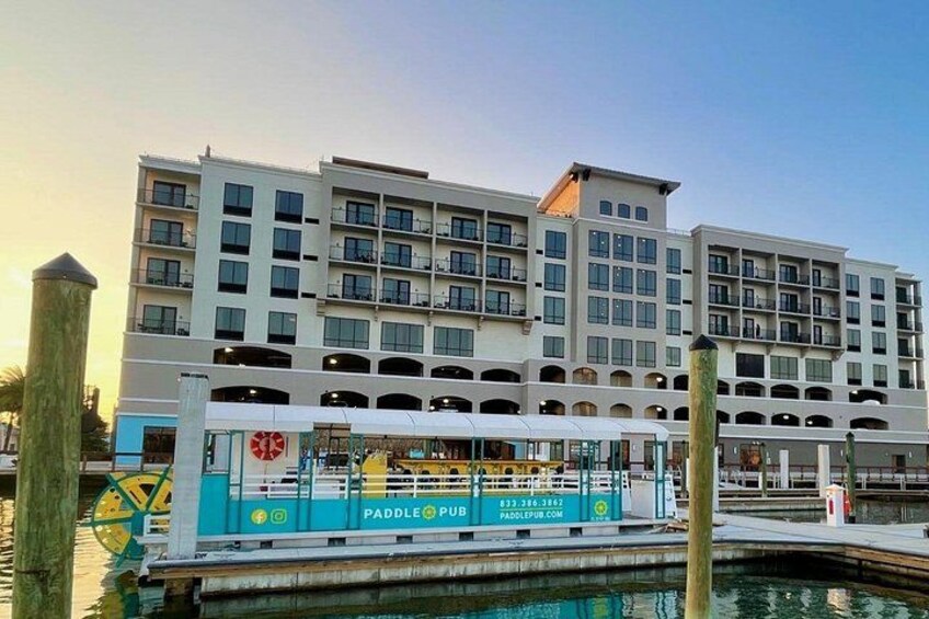 A multi-story hotel with a dock and a paddle boat in the foreground. 5