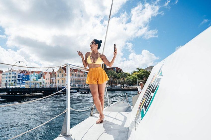 Una donna in costume da bagno giallo su una barca, con uno skyline urbano sullo sfondo. 3