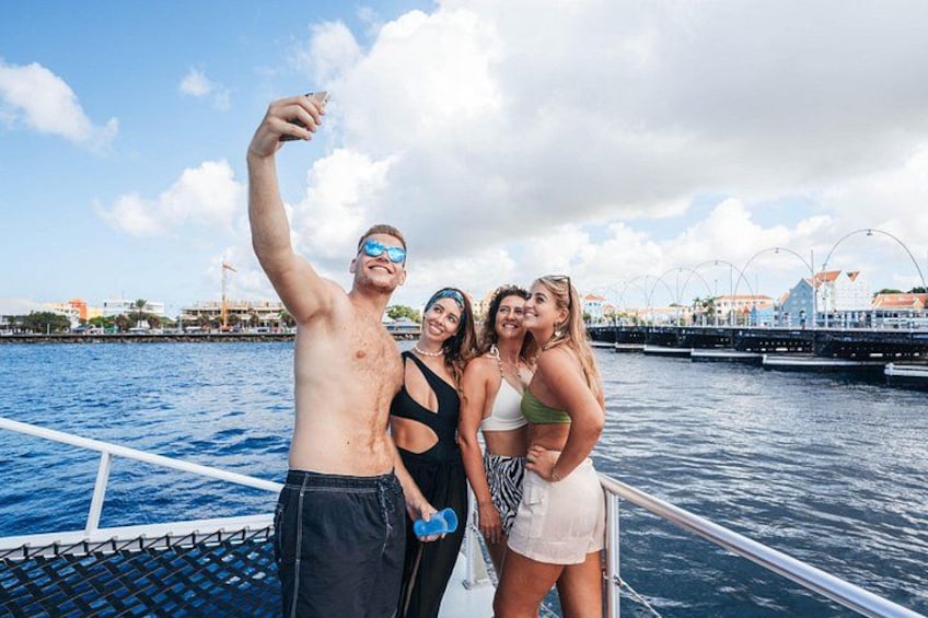 Una persona si fa un selfie su una barca, con uno skyline urbano sullo sfondo. 2