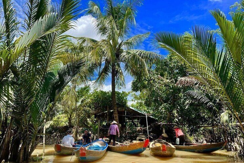 A tropical setting with palm trees, a wooden structure, and several traditional boats. 5