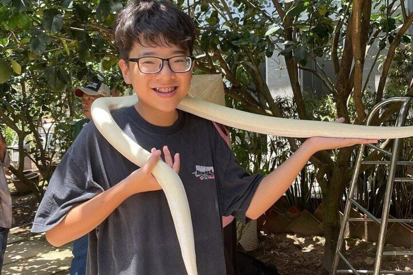 A person holding a large snake. 3