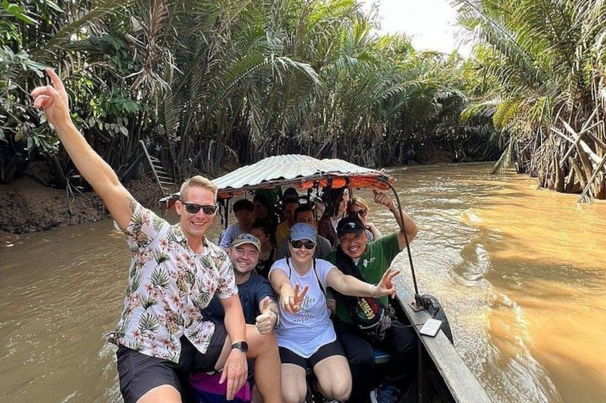 A group of people on a boat in a river surrounded by dense vegetation. 1