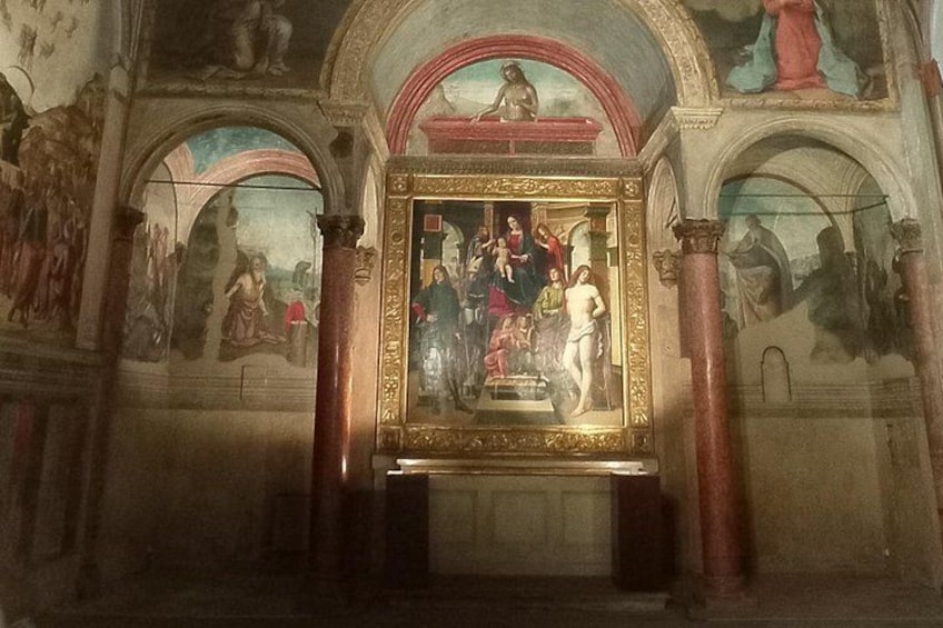 Ein Kircheninneres mit einem zentralen Altar, Fresken und Säulen. 2