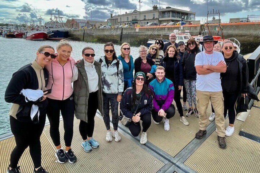 A group of people on a dock with boats in the background. 5
