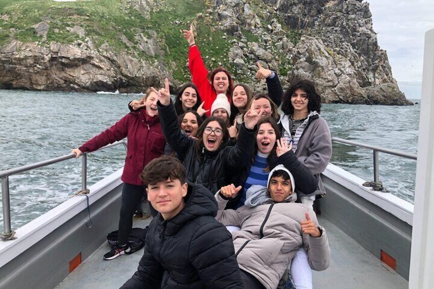 A group of people on a boat near rocky cliffs. 4