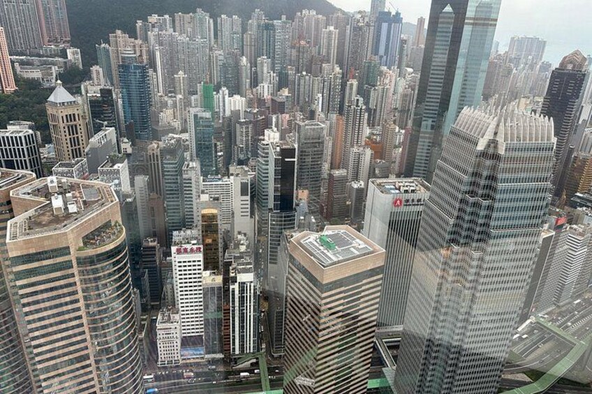 Un horizonte urbano denso con edificios altos, una estructura curva destacada y una plaza central. 4