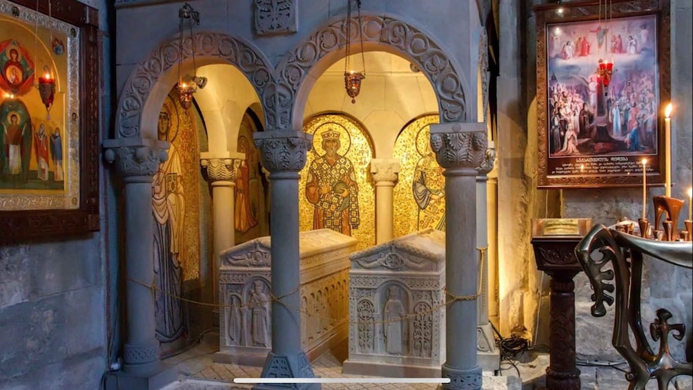 An ornate church interior with golden mosaics, a central altar, and religious paintings. 5