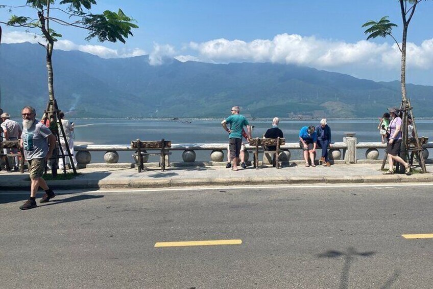 People standing by a waterfront with mountains in the background. 5