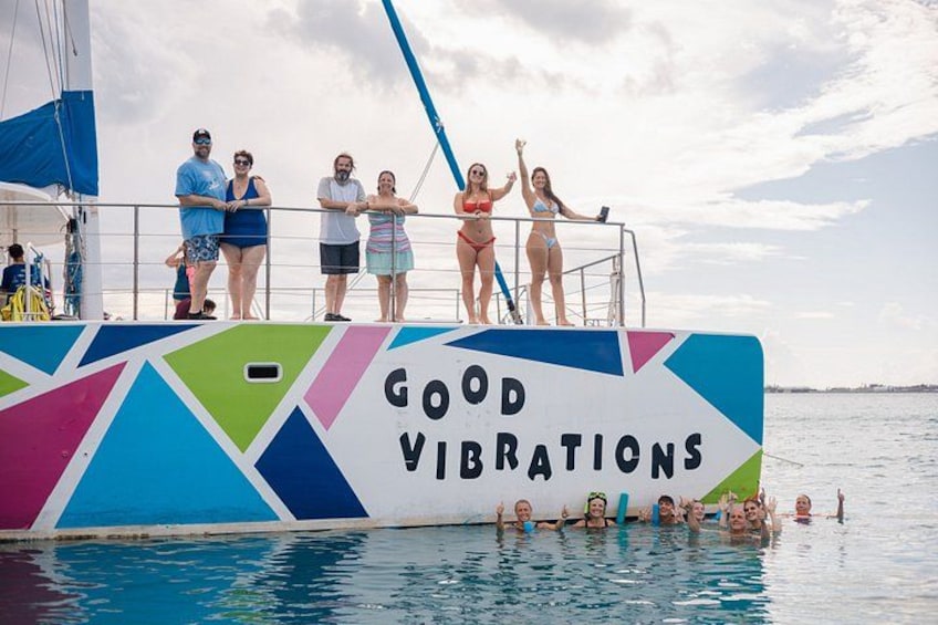En farverig båd med teksten 'GOOD VIBRATIONS' på skroget, omgivet af vand. 3