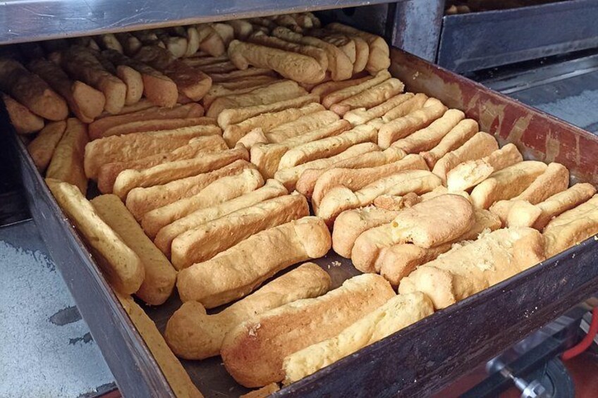 A large metal tray filled with golden-brown bread rolls. 3