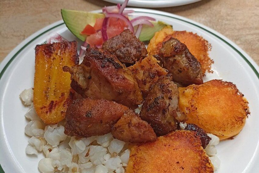 A plate with grilled meat, fried plantains, and a side of white rice. 4