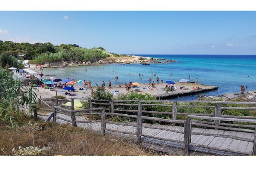 A beach with people, umbrellas, and a wooden walkway. 3
