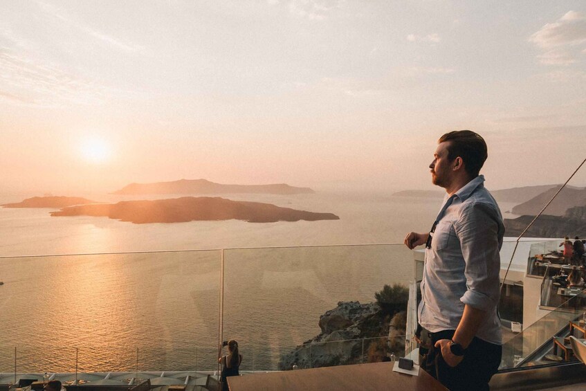 A man overlooking a coastal landscape with a sunset. 2