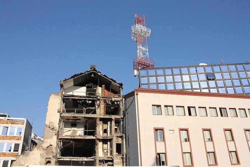 A damaged building with exposed structural elements and a clear sky. 2