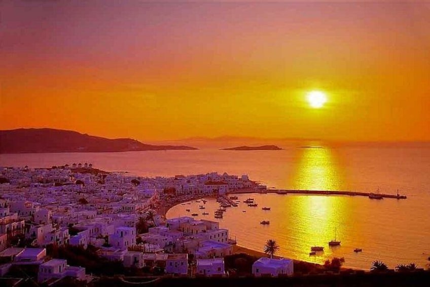 A coastal town at sunset with buildings, a pier, and boats. 4