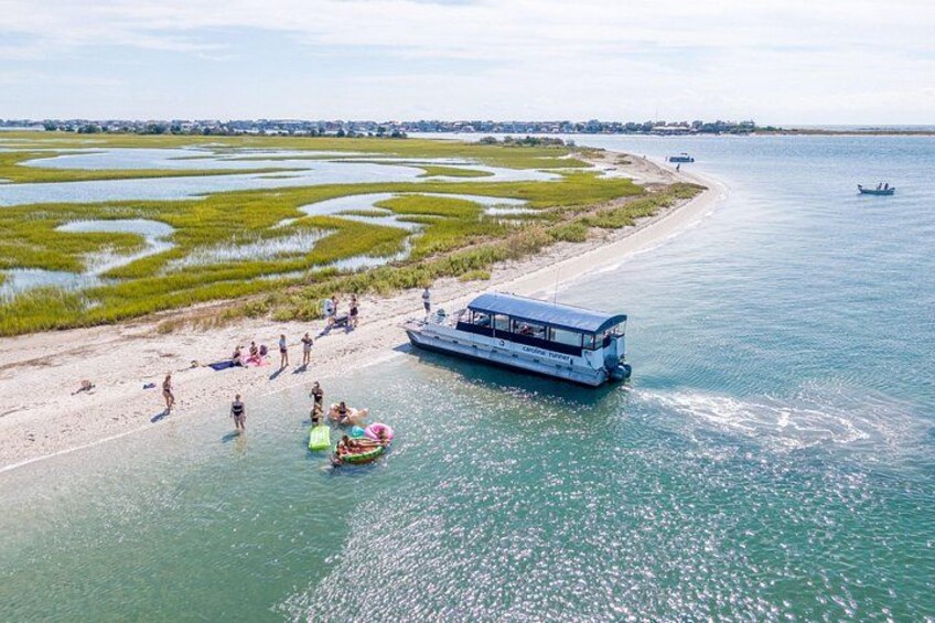 Un bote en un río, gente en la orilla y una playa con agua. 5