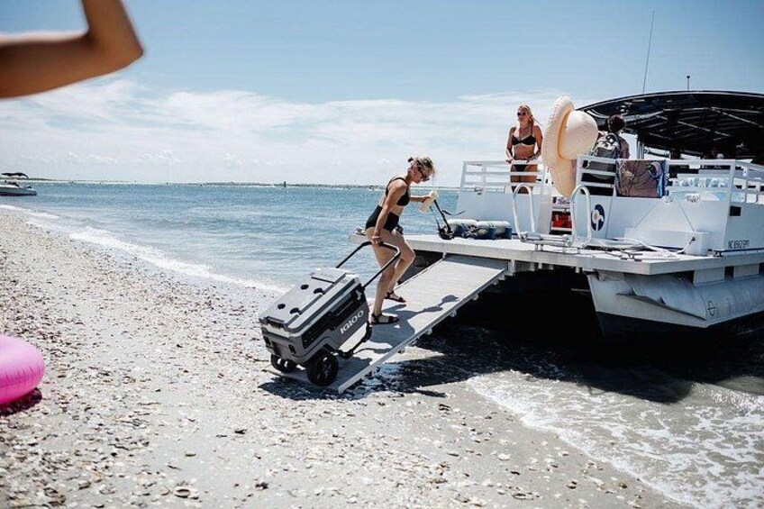 Una persona sube a una embarcación con un remolque en una playa arenosa. 3