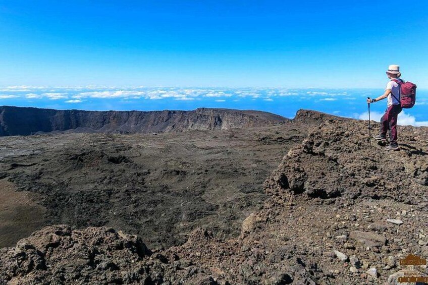 Un escursionista in cima a una montagna rocciosa sotto un cielo sereno. 1