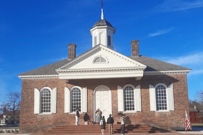 A brick building with a central tower and arched windows. 1