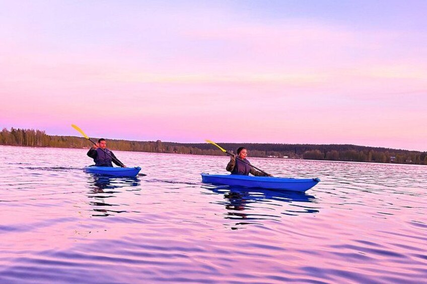 Dos personas haciendo kayak en un lago tranquilo con un cielo rosado. 2